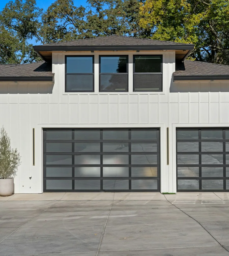 Sun-exposed garage doors on a home exterior in full daylight