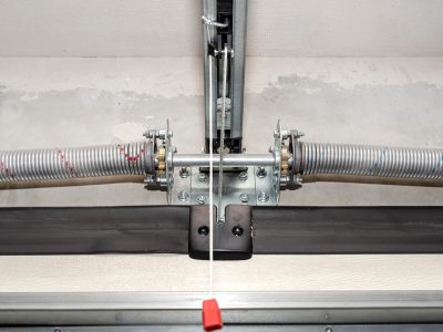 Springs tensioning the home garage door mechanism, view from the inside, visible rail with chain.