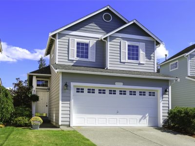 Two story house with small entrance porch and garage with driveway