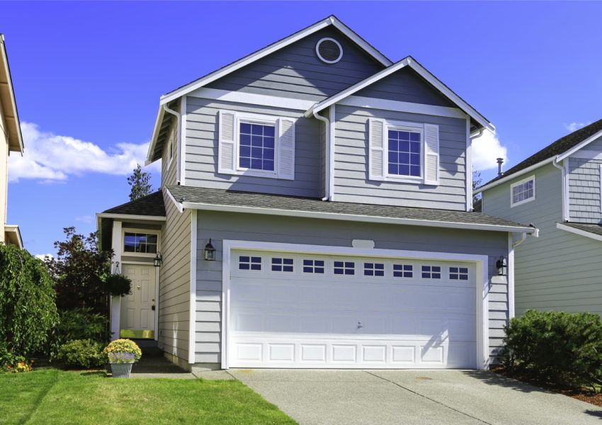 Two story house with small entrance porch and garage with driveway