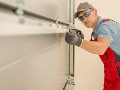 Installing Brand New Residential Garage Doors by Professional Caucasian Technician in His 40s.